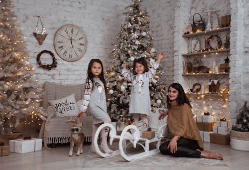 Mother with Her Daughters Among Christmas Decorations 