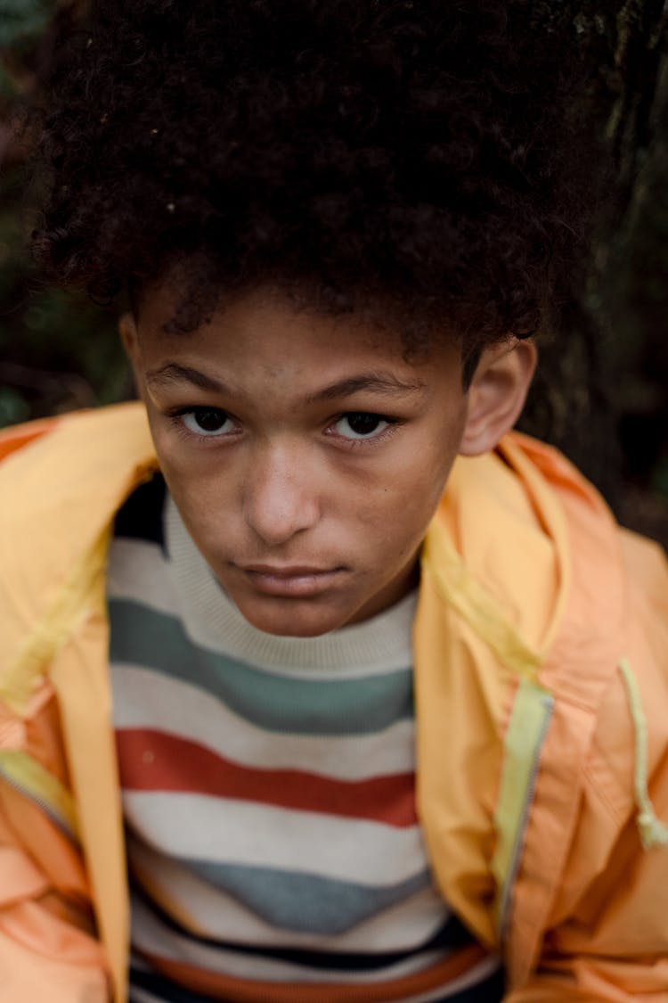 Portrait Of Sad Teenage Boy In Yellow Raincoat