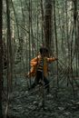 Teenage Boy in Yellow Raincoat Running in Forest