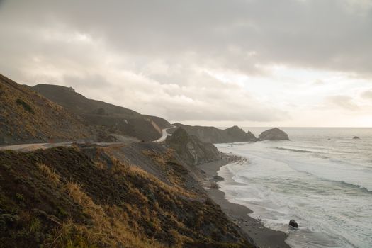 Captivating view of California's rugged coastline with waves crashing against the cliffside.