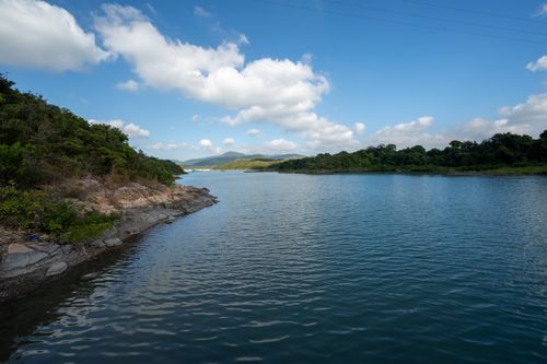 Free A serene view of Sai Kung's tranquil waters with lush greenery and clear blue skies. Stock Photo