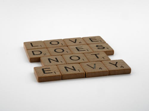 Close-Up Shot of Scrabble Tiles on a White Surface