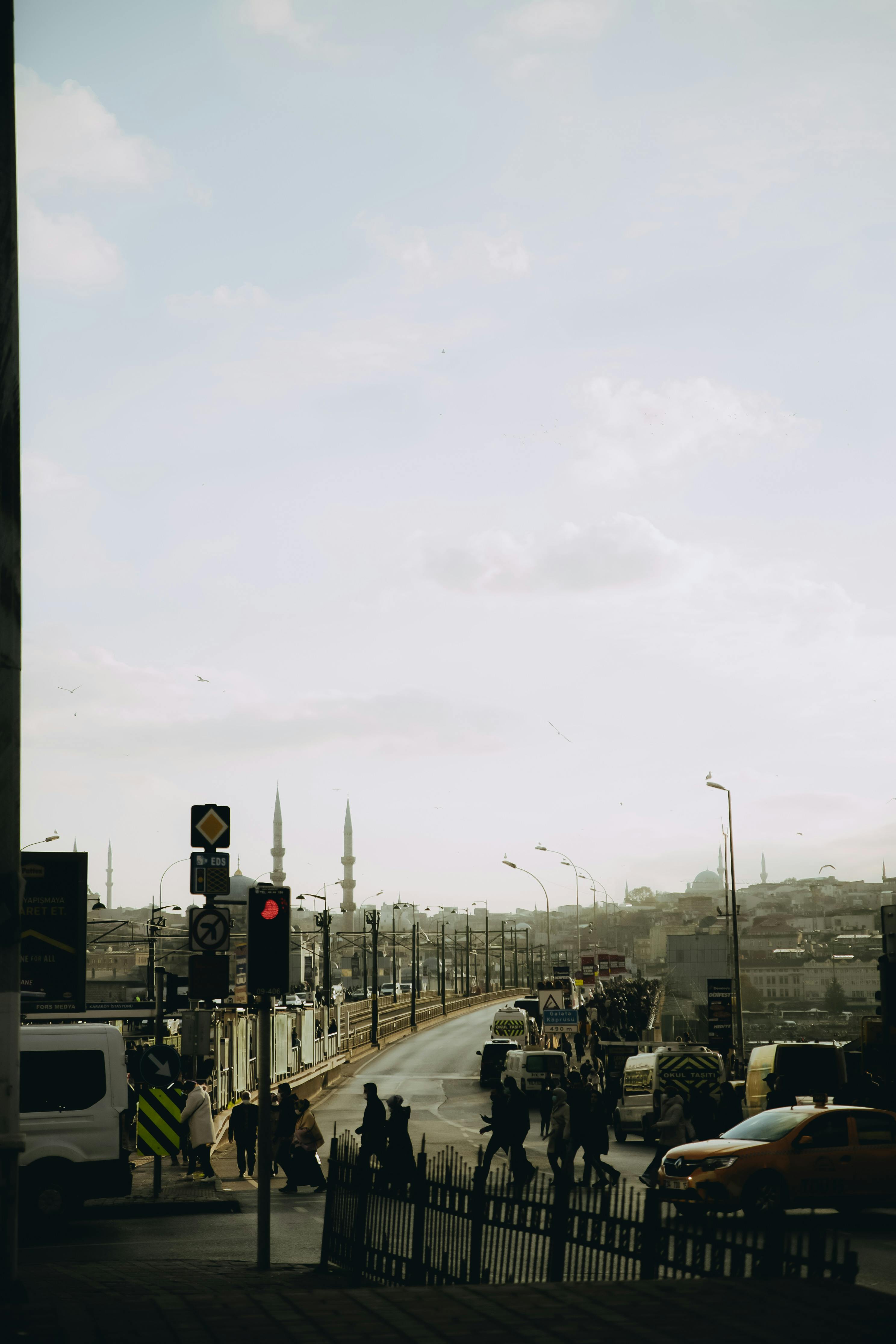 Busy urban street scene featuring traffic and pedestrians under a clear sky.