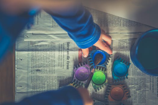 一个孩子在报纸上用水彩画创作充满活力的艺术作品