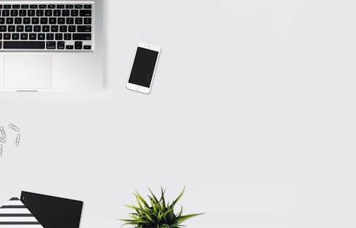 White Smartphone Beside Silver Laptop Computer