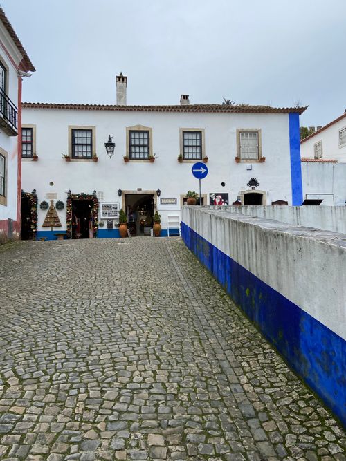 Free A picturesque cobblestone street leading to a historic building in Obidos, Portugal. Stock Photo