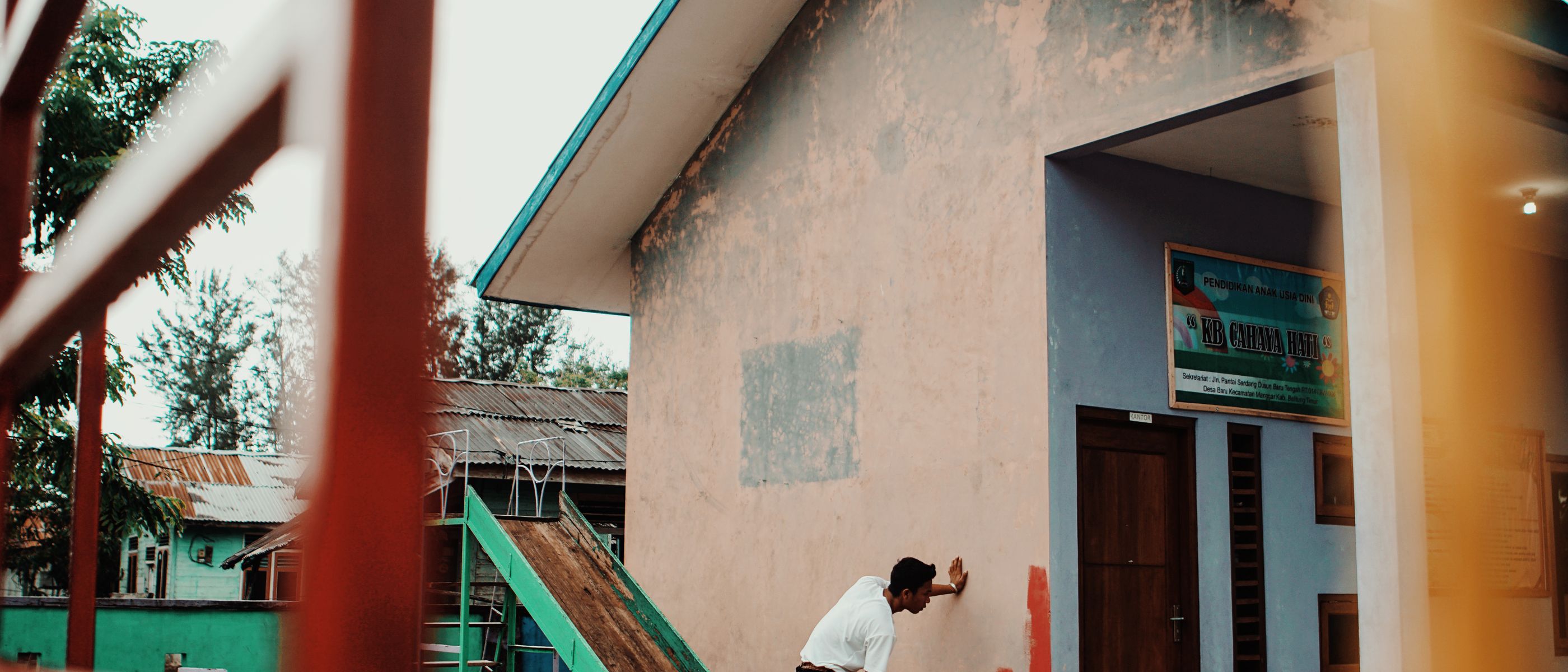 Painter refreshing a building's exterior wall in the sunshine