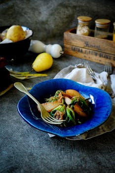 A rustic pear salad beautifully presented in a vibrant blue bowl on a kitchen worktop.