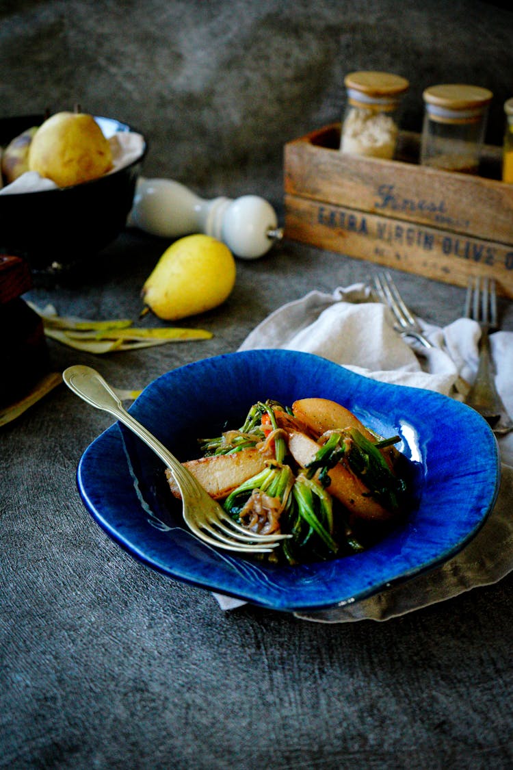 Fried Vegetables With Potato Wedges In Blue Bowl On Kitchen Worktop