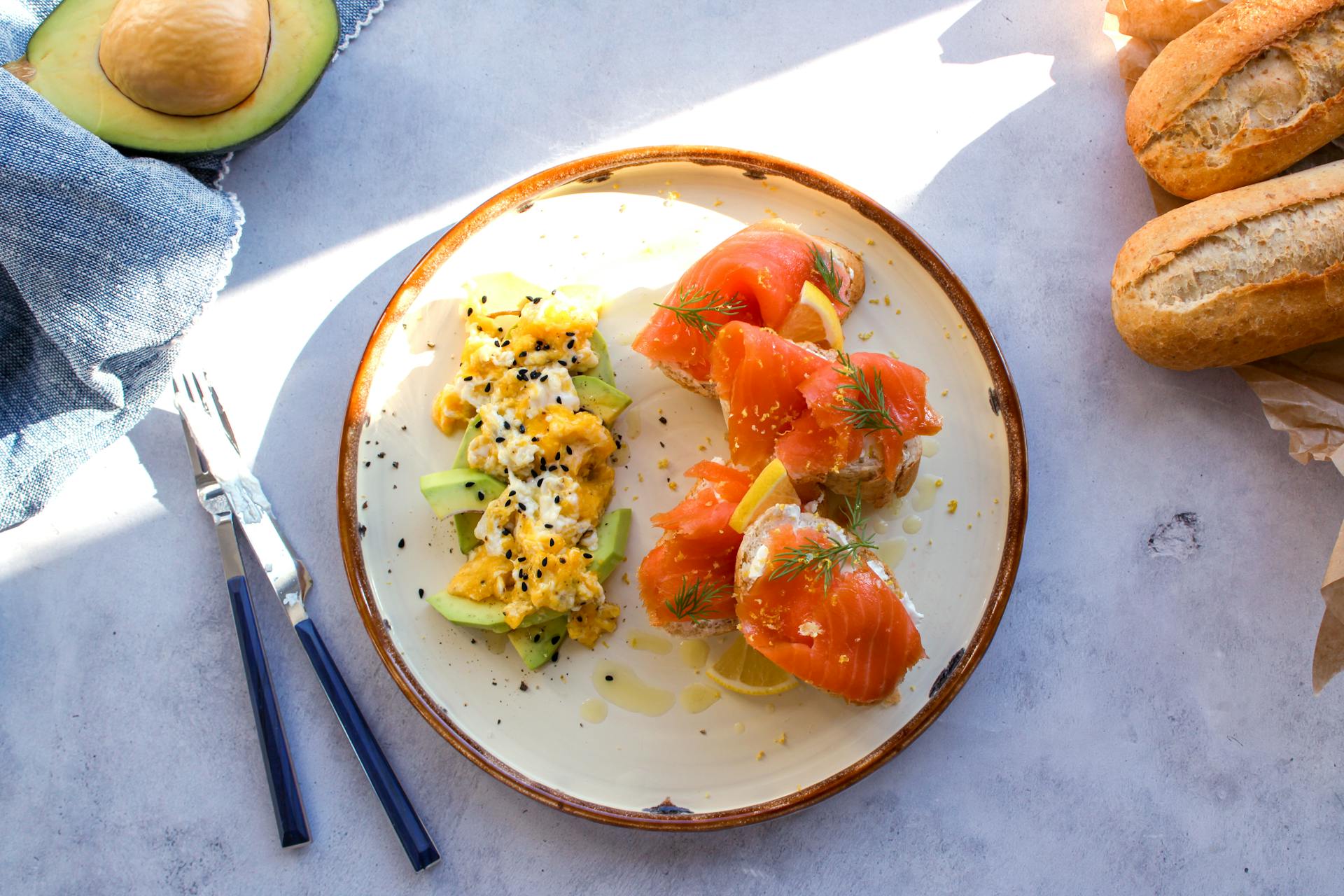 Appetizing Salmon Chunks with Lemon Wedges and Avocado Salad