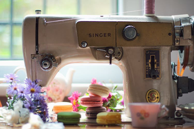 Colourful Cookies And Flowers Left Around Vintage Sowing Machine