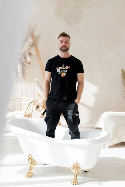 Man in Black Shirt Standing on a Bathtub