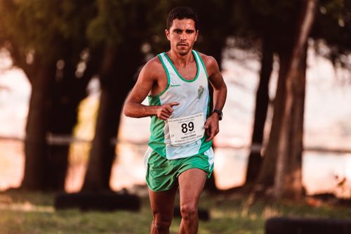 Free Male athlete determinedly running in an outdoor marathon event, captured in motion. Stock Photo