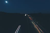 这张迷人的夜间高速公路长曝光照片，捕捉了月光下移动的车灯