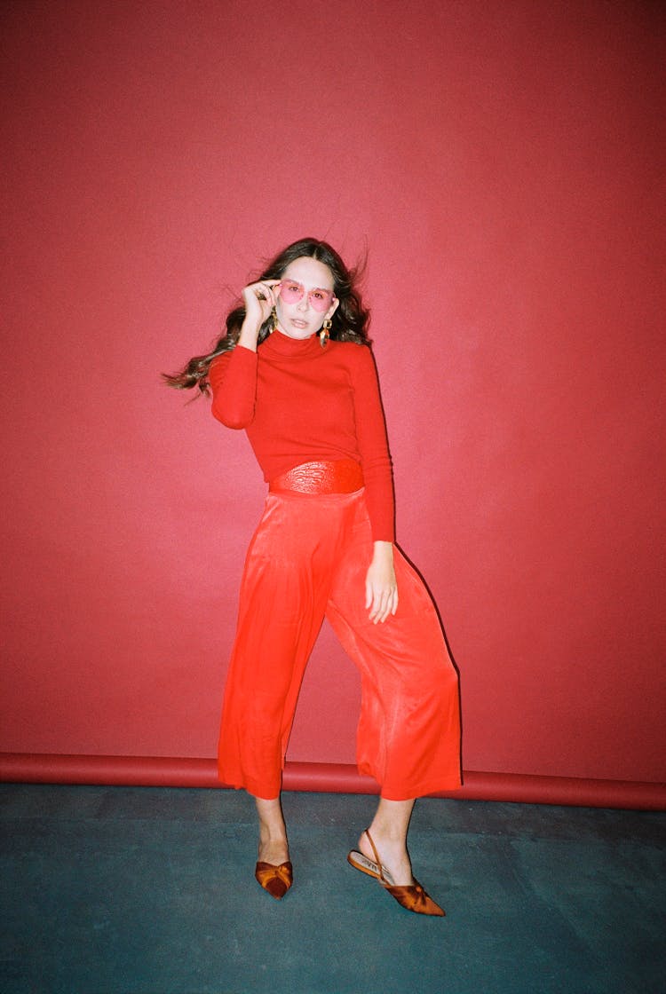 Woman In Red Clothes Standing On A Red Background