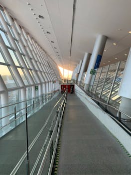 Spacious modern airport terminal hallway with expansive windows and sleek design.