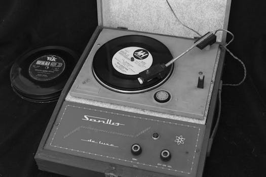 Classic monochrome photo showcasing a vintage record player and vinyl records.