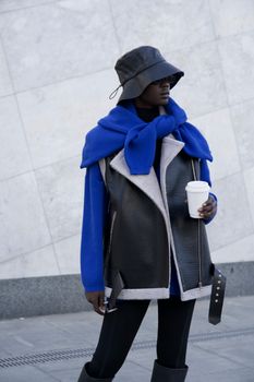 Unrecognizable Person in Black Leather Vest and Hat Standing in Street