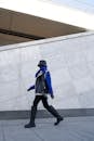 Unrecognizable Person in Big Boots Walking Along Concrete Urban Structure