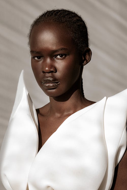 Young Woman with African Hairstyle Posing in Snowy White Dress 