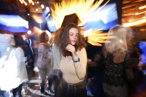Free Vibrant nightclub scene with woman dancing under dynamic lights, capturing the night's energy. Stock Photo