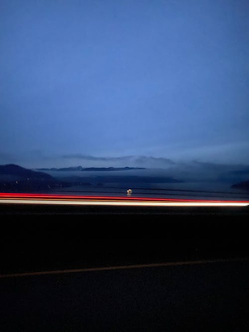 Black Asphalt Road Under Blue Sky during Night Time