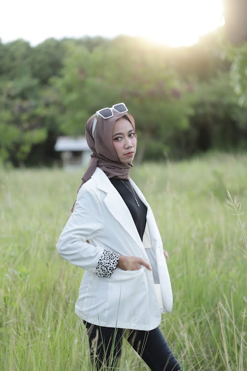 Woman in White Coat Standing on Green Grass Field