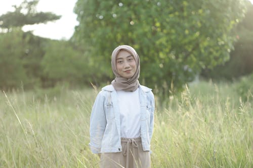 Woman in Brown Hijab Standing on Grass Field