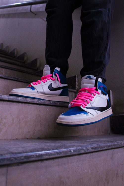 Free Fashion-forward sneakers with bold pink laces spotted on stairs, perfect for urban style inspiration. Stock Photo