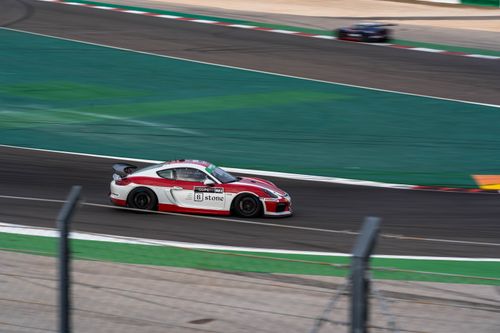Free Exciting capture of a red and white racecar speeding through a motorsport track. Stock Photo