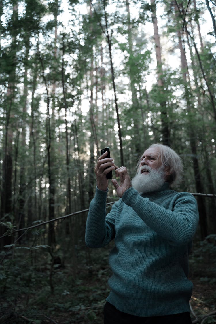 Man In Green Sweater  Lost In Forest Using Smartphone 