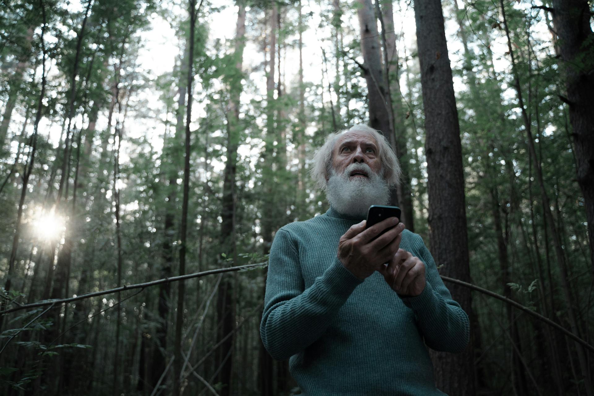 Scared Man Lost in Forest Holding Mobile Phone