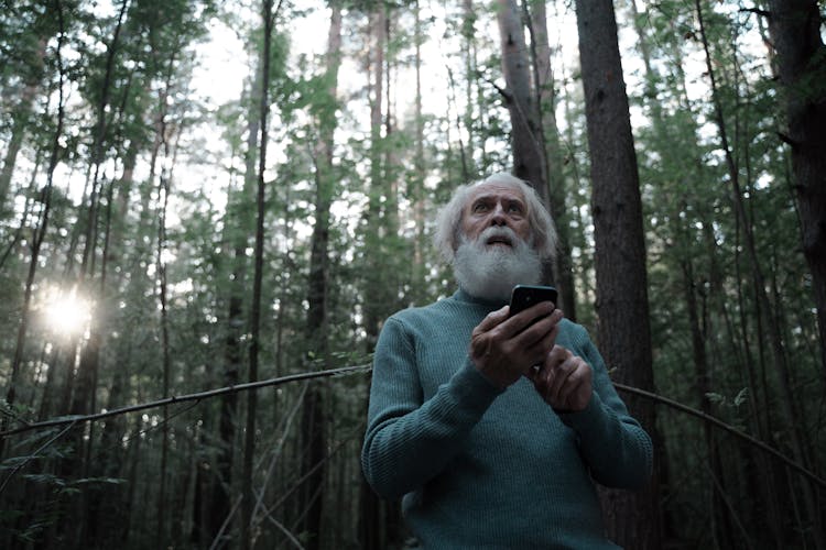 Scared Man Lost In Forest Holding Mobile Phone 