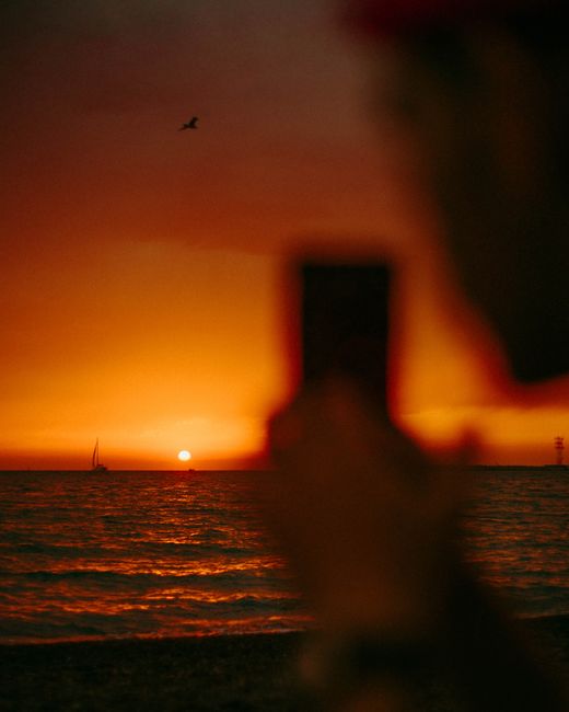 Beautiful backlit sunset over the sea with sailing boat, captured in Sochi.
