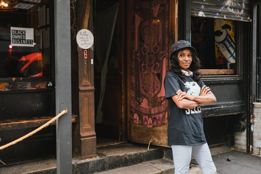 Patronne de PME souriante devant son commerce