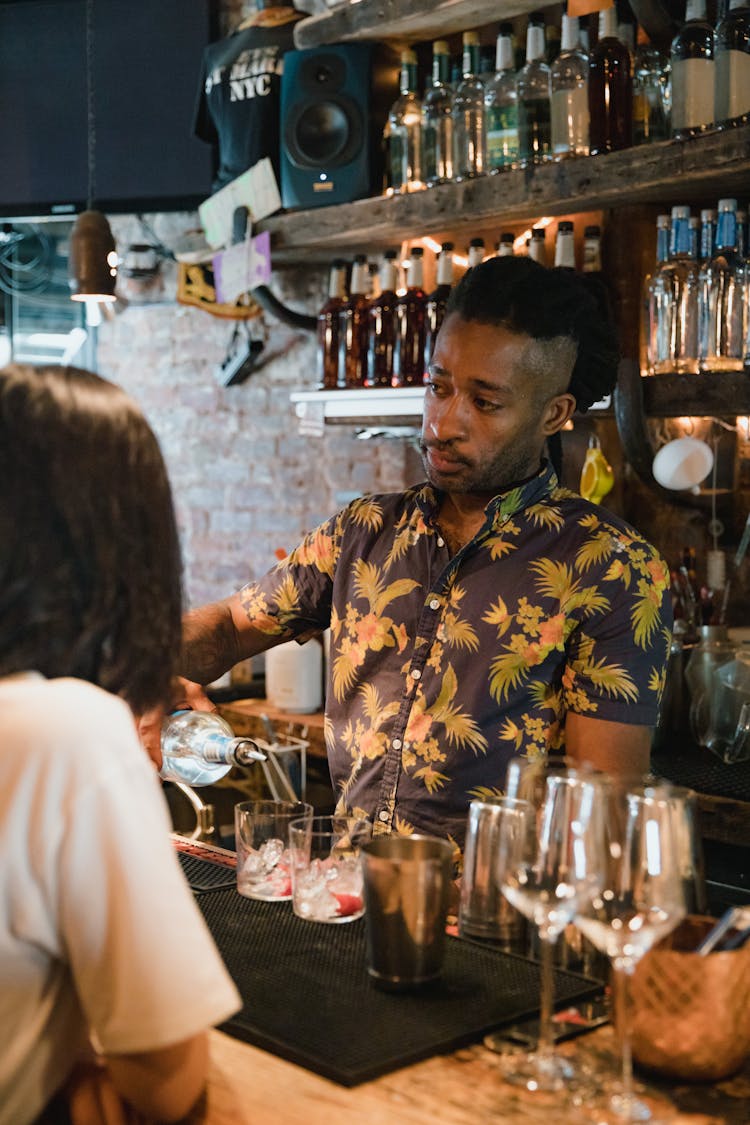 Bartender Preparing Cocktail For Customer At Bar