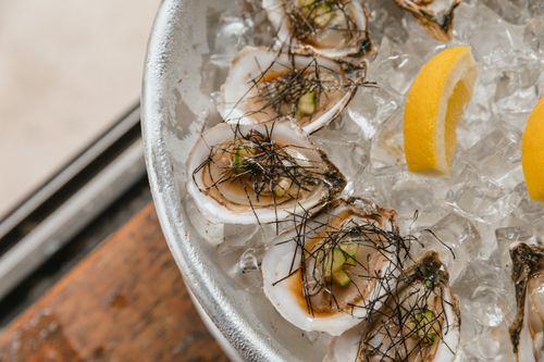 Free A close-up of gourmet oysters on ice with lemon slices, perfect for culinary inspiration. Stock Photo