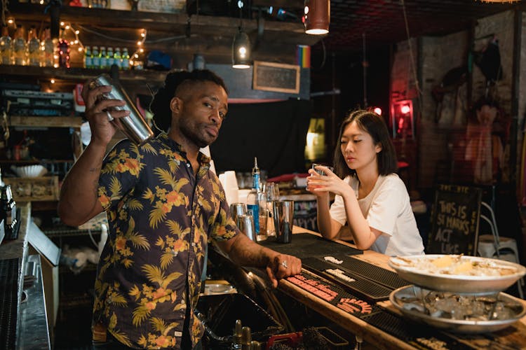 Bartender Preparing Cocktail For Customer At Bar