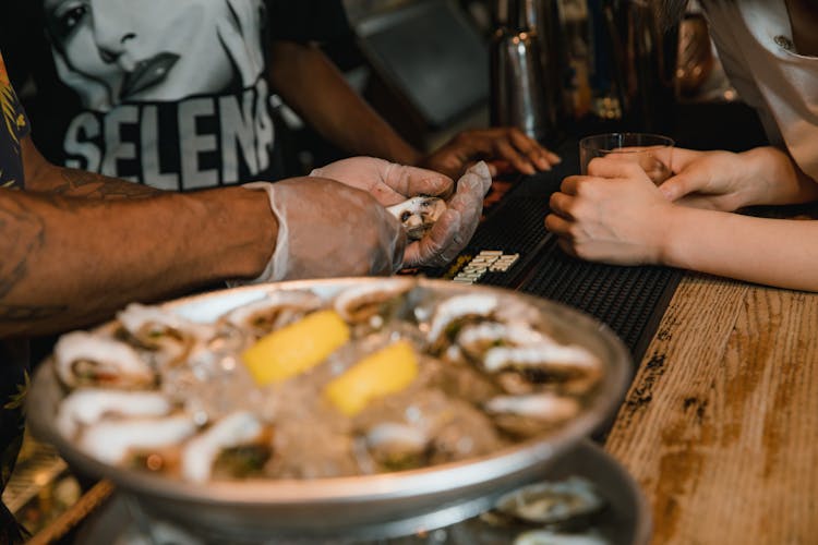 Mand And Woman And Seafood At Bar Counter