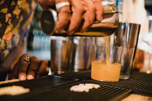 Man Pouring Cocktail into Drinking Glass