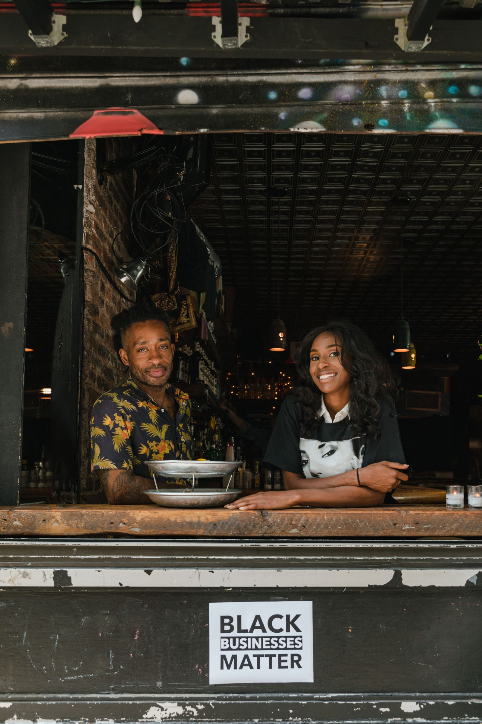 Two smiling entrepreneurs working together in a Black-owned business