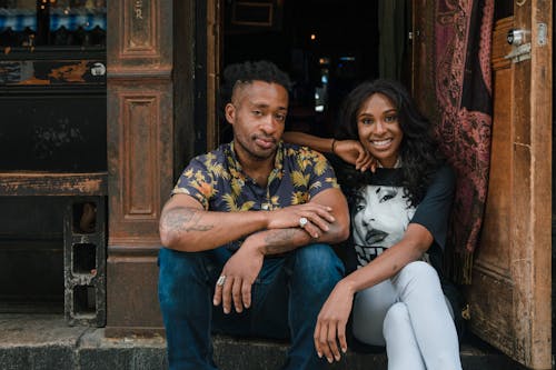 Man and Woman Sitting on Steps in front of Bar