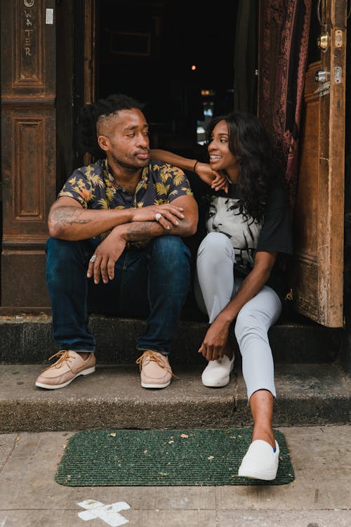 Smiling Man and Woman Sitting at Cafe Doors