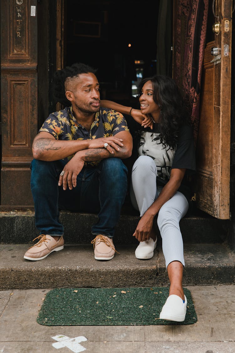 Smiling Man And Woman Sitting At Cafe Doors