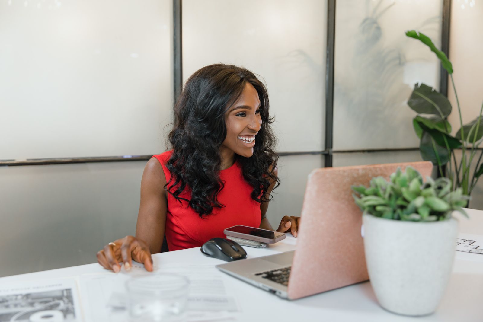 Woman seated in front of a laptop in a studio space.