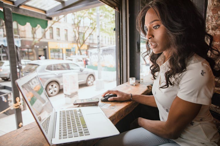 Woman Working On Laptop On Window Sill 