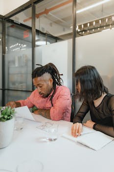 A diverse team of two professionals working on a project in a modern office setting.