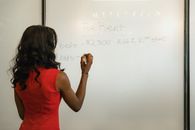 Woman in Red Writing on a Whiteboard
