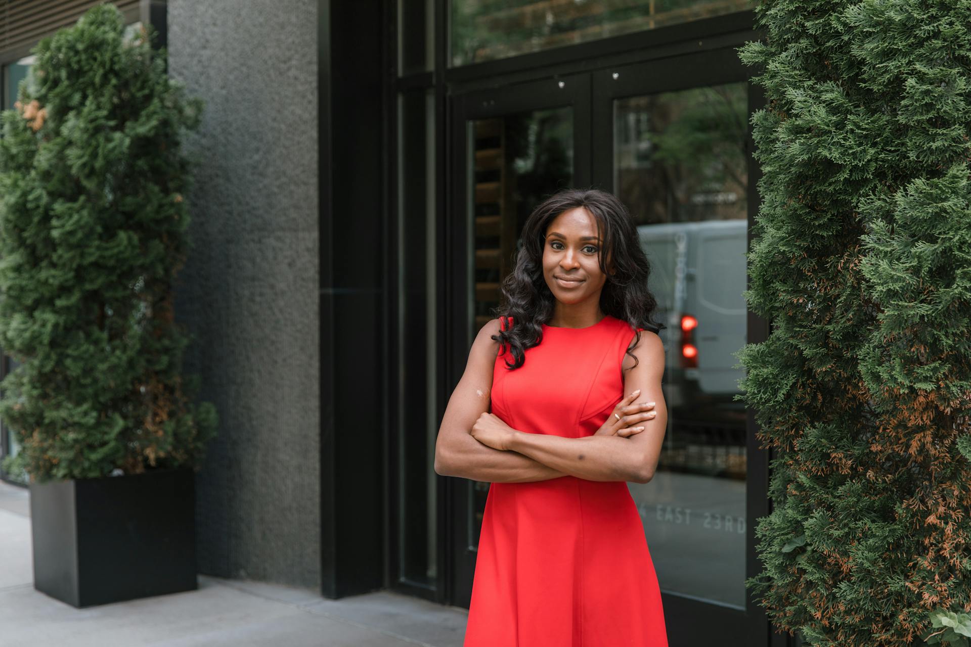 Smiling woman in red dress in front of office building