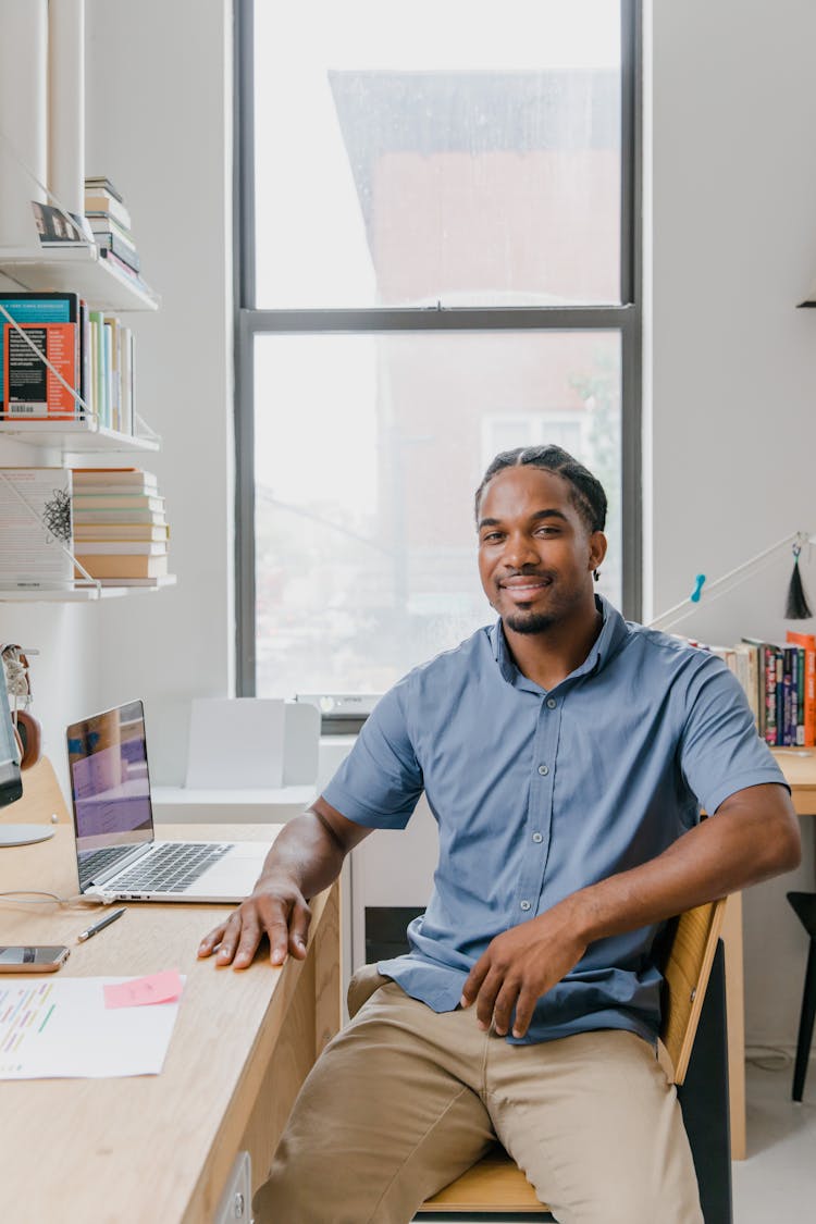 Smiling Man Sitting At Desk In Office